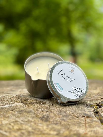 Bougie de massage EAU – packshot fond blanc, fleur de lotus et beurre de karité